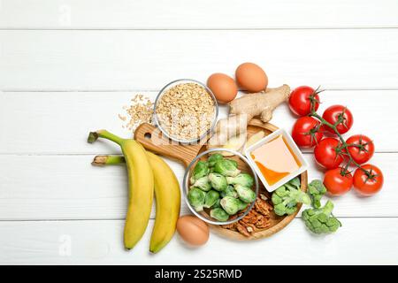 Verschiedene frische Produkte reich an Melatonin auf weißem Holztisch, flach gelegt Stockfoto