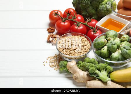 Verschiedene frische Produkte mit hohem Melatoningehalt auf weißem Holztisch, Platz für Text Stockfoto