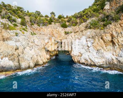 Ein atemberaubender Blick auf zerklüftete Klippen und üppiges Grün, das auf das pulsierende blaue Meer trifft. Fängt die Schönheit und Ruhe der Küstenlandschaften ein und bietet einen Stockfoto