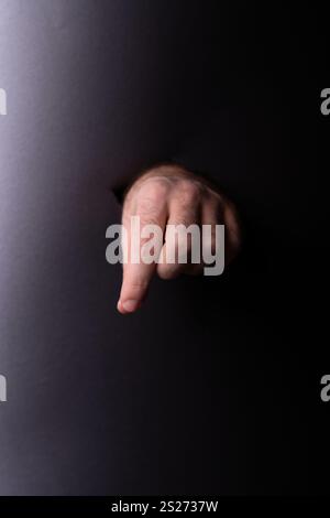 Fotoexpressive Darstellung einer faszinierenden Handgeste, die Kommunikation, Gebärdensprache, nonverbale Cue mit dunklem minimalistischem Hintergrund symbolisiert Stockfoto