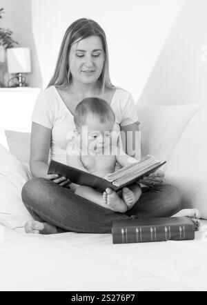 Schwarz / weiß Porträt des Lächelns Lesebuch junge Mutter auf ihr baby Stockfoto