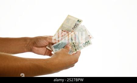 Frau, die tschechische Krone in den Händen hält, vor einem isolierten weißen Hintergrund Stockfoto