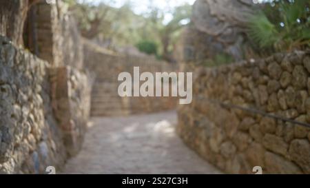 Verschwommene Outdoor-Szene auf mallorca mit unscharfen Steinwegen mit Wänden auf beiden Seiten und Bokeh-Effekt im Hintergrund Stockfoto