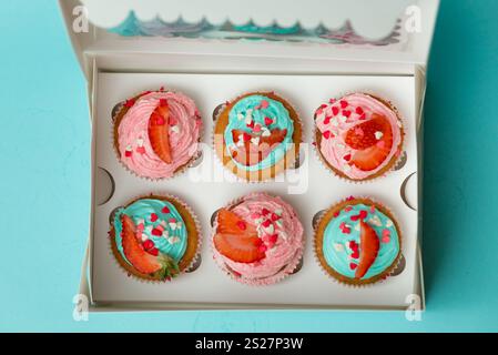 Blick von oben auf Cupcakes mit Streuseln und Erdbeeren in der Box Stockfoto