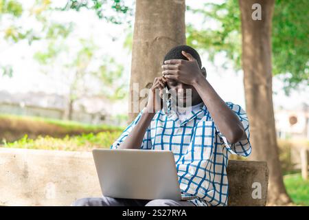 Bild eines aufgeregten jungen afroamerikanischen Mannes, der auf Laptop-Computer einsetzt. Internet, Verbindung, Technologie Stockfoto