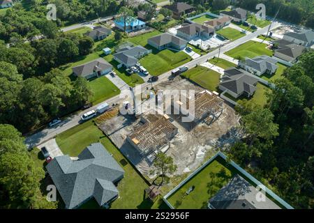 Bauarbeiter, die an der Dachkonstruktion eines unfertigen Wohnhauses mit Holzrahmenstruktur im Vorstadtgebiet von Florida arbeiten. Wohnungsbau Stockfoto
