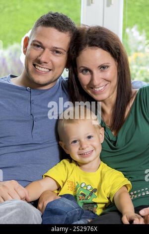 Eine junge Familie sitzt auf einer Couch Austria Stockfoto
