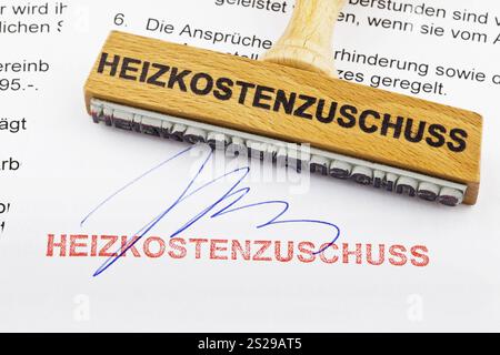 Ein Holzstempel liegt auf einem Dokument. Deutsche Inschrift: Heizkostenzuschüsse Österreich Stockfoto