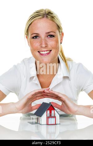 Eine Frau beschützt Ihr Haus und Ihr Zuhause. Gute Versicherungen und seriöse Finanzierungen sorgen für ein beruhigendes Gefühl. Österreich Stockfoto