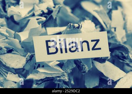 Papierschredder mit Schlüsselwort Bilanz, symbolischem Foto für Datenvernichtung, Ausgleich und wirtschaftliche Analyse Stockfoto