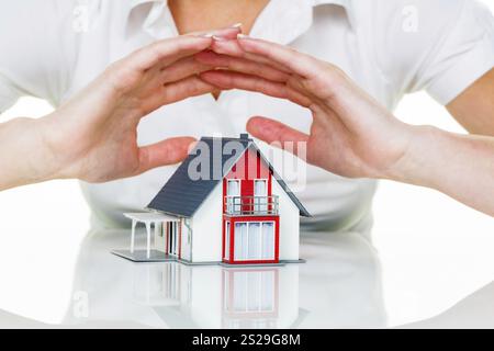 Eine Frau beschützt Ihr Haus und Ihr Zuhause. Gute Versicherungen und seriöse Finanzierungen sorgen für ein beruhigendes Gefühl. Österreich Stockfoto