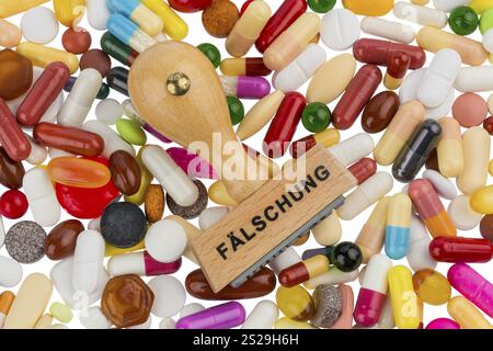 Stempel auf farbigen Tabletten, symbolisches Foto für gefälschte Arzneimittel und Produktpiraterie Stockfoto