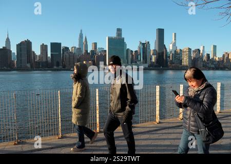 New York, Usa. Januar 2025. Die Menschen laufen im Hunter's Point South Park in Long Island City, Queens, New York City, während man einen Blick auf Manhattan im Hintergrund hat. Quelle: SOPA Images Limited/Alamy Live News Stockfoto