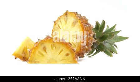 Hellgelbe Ananas mit grünen Blättern, mit frischen Scheiben, die attraktiv auf einer weißen Oberfläche platziert werden. Stockfoto
