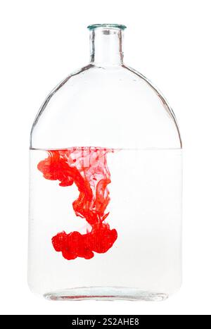 Rote Tinte löst sich in Wasser in Glasflasche isoliert auf weißem Hintergrund Stockfoto