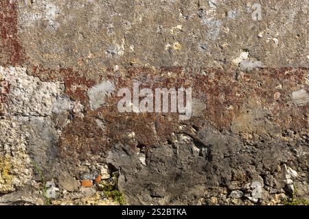 Detail einer Granitmauer mit Zement, großen und kleinen grauen Steinen, die übereinander gestapelt sind, Teil eines alten historischen portugiesischen Hauses. Stockfoto