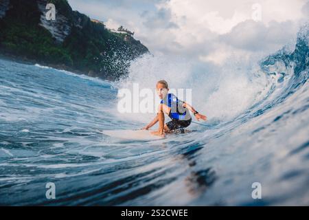 Januar 2021. Bali, Indonesien. Kindersurfer fahren auf dem Surfbrett bei Ocean Wave in Uluwatu. Stockfoto