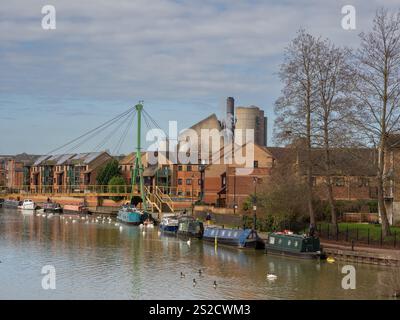 Blick auf den Fluss Nene bei Southbridge, Northampton, Großbritannien; mit modernen Wohnhäusern, verankerten Schmalbooten und der Wathen Wigg Bridge Stockfoto