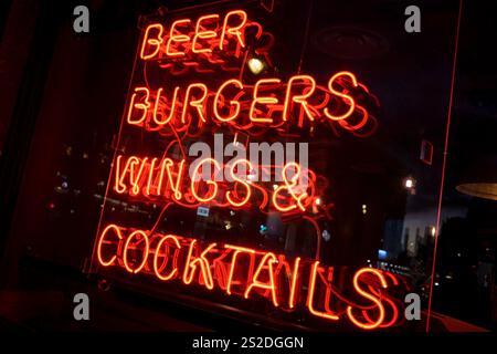 Ein Fast-Food-Händler listet seine Speisen und Getränke am 7. Januar 2025 in London in einem dunklen Soho-Fenster auf. Stockfoto