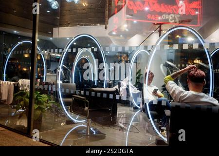 Am 7. Januar 2025 in London, England, liegt ein Mitarbeiter auf dem Sitz eines Friseurkunden. Stockfoto