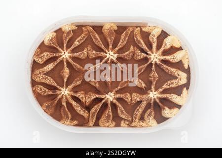 Tiramisu-Eis im Plastikbehälter auf weißem Hintergrund – elegantes gefrorenes Dessert Bild Stockfoto