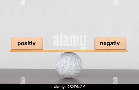 Positiv und negativ im Gleichgewicht auf einer Wippe sind positiv und negativ im Gleichgewicht *** positiv und negativ im Gleichgewicht positiv und negativ Stockfoto