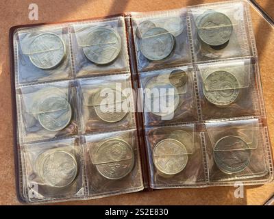 Kiew, Ukraine - 07. Januar 2025: Eine organisierte Ausstellung einer Münzsammlung in einem Schutzalbum, in dem verschiedene alte Münzen mit komplizierten Mustern gezeigt werden Stockfoto