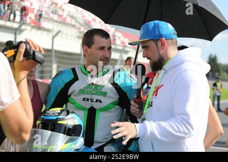 MOSKAU, RUSSLAND - 21. JULI 2019: Gastgeber des Wettbewerbs befragt einen der Teilnehmer vor dem Start der russischen Meisterschaft im Motorsport Stockfoto