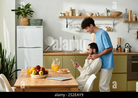 Zwei Männer genießen ein gemütliches Frühstück in ihrem modernen Apartment und teilen Momente der Liebe. Stockfoto