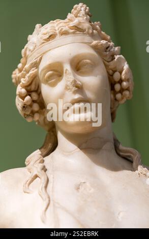 Nahaufnahme des Gesichts in Ruinen einer antiken römischen Statue aus Marmor, die eine schöne Frau mit einem schicken Friseur darstellt Stockfoto
