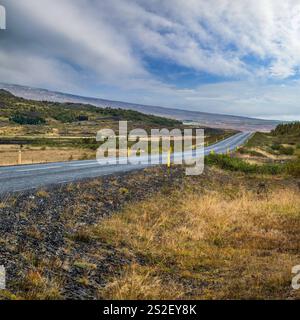 Asphaltstraße und Blick auf die Berge während der Autotour in Island. Spektakuläre Herbst isländische Landschaft mit landschaftlich reizvoller Natur. Stockfoto