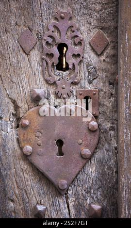 Alte verwitterte Tür mit herzförmigem Schlüsselloch. Romantischer Hintergrund im Retro-Stil. Öffne dir das Herz, Homme ist, wo Liebe Konzepte ist. Stockfoto