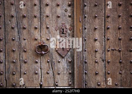 Alte verwitterte Tür mit herzförmigem Schloss, Schlüsselloch und Griff. Vintage-grungy-romantischer Hintergrund. Öffne dir das Herz, Homme ist, wo Liebe Konzepte ist. Stockfoto
