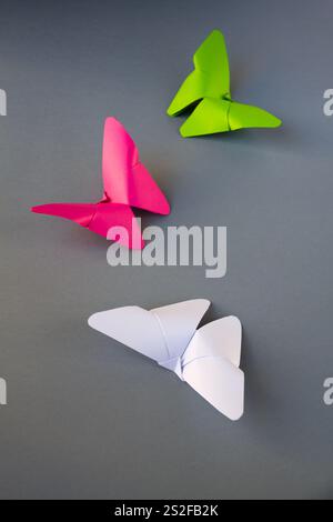 Grün, rosa und weiß Papier Schmetterling Origami isoliert auf einem weißen grauen Hintergrund. Stockfoto