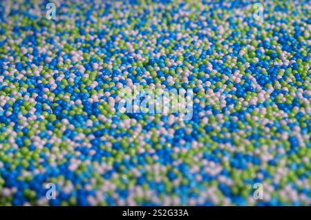 Hintergrund Bild von einer Vielzahl von farbig glasierten Pulver in Form von kleinen Kugeln. Eine große Anzahl von süßen, bunten Perlen von sehr kleinen Größe für dec Stockfoto