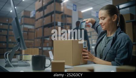 Die Lagerbestandsmanagerin scannt das Paket mit einem Barcode-Scanner, bereitet den Versand an den Kunden vor, arbeitet am Computer. Kontrollkästchen des Lagermitarbeiters für den Versand. E-Commerce-Geschäft oder Postdienst. Stockfoto