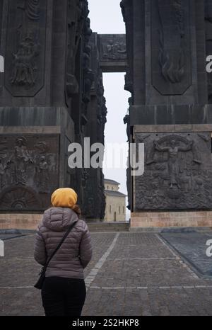 Eine Frau besucht im Winter das Monument Chroniken von Georgien in Tiflis. Mit Steinsäulen, Skulpturen, Geschichte und Panoramablick. Stockfoto