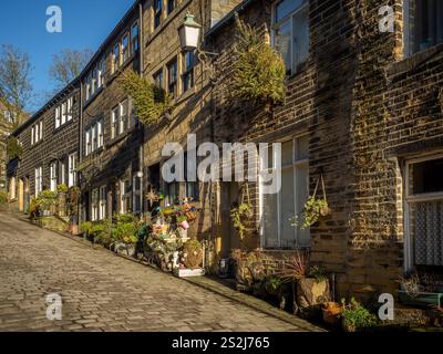 Reihenhäuser an der steilen Main Street in Haworth, West Yorkshire, Großbritannien Stockfoto