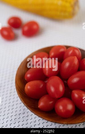 Tomaten und Mais auf ein weißes Tuch gelegt. Selektiver Fokus. Stockfoto