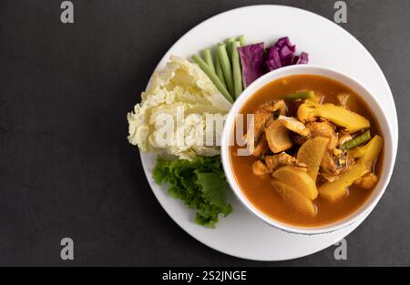 Gelbes Curry mit Schlangenkopf, thailändisches Essen in einer Schüssel auf einem Teller mit Yard langer Bohne, gebratenem Weißkohl, Salat und Purpurkohl Stockfoto