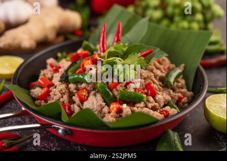 Gebratenes Schweinebrauchbasilikum auf Bananenblättern in einer Pfanne. Thailändisches Essen. Stockfoto