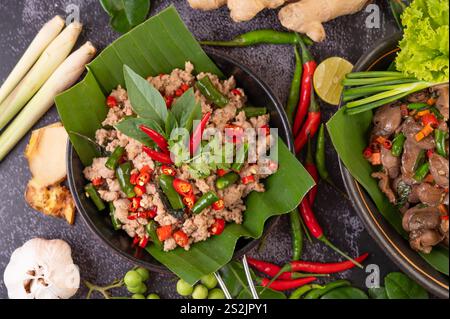 Gebratenes Schweinebrauchbasilikum auf Bananenblättern in einer Pfanne. Thailändisches Essen. Stockfoto