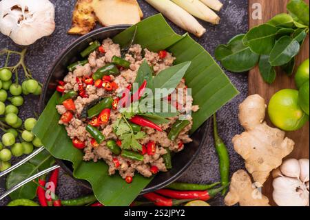 Gebratenes Schweinebrauchbasilikum auf Bananenblättern in einer Pfanne. Thailändisches Essen. Stockfoto