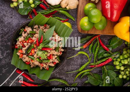 Gebratenes Schweinebrauchbasilikum auf Bananenblättern in einer Pfanne. Thailändisches Essen. Stockfoto