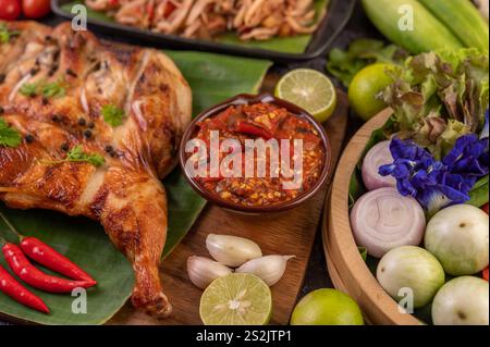 Gegrilltes Huhn auf einem Teller mit Chili-Paprika, Knoblauchsoße und mit Pfefferkernen bestreut. Stockfoto