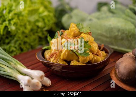 Shumai oder Kanom Jeeb oder gedämpfte Schweineknödel auf einem Teller, bestreut mit Koriander und frittierten Zwiebeln. Stockfoto