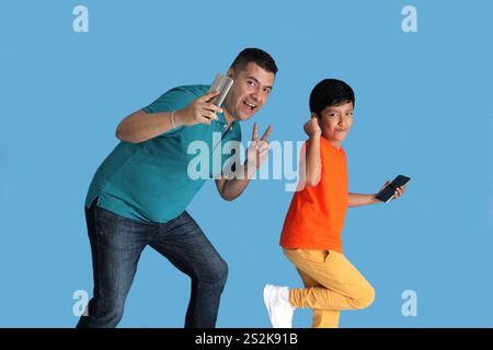 Geschiedener Alleinvater mit seinem 9-jährigen dunkelhäutigen Latino-Sohn tanzen als Zeichen von Sieg und Triumph beim Spielen und Spaß Stockfoto