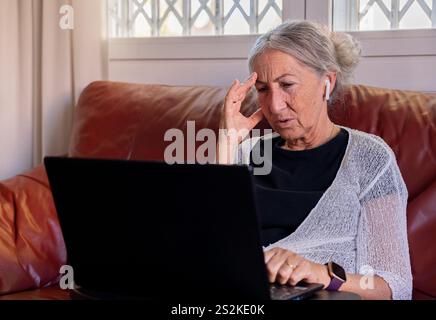 Frau im Ruhestand, die technische Probleme hat. Stockfoto