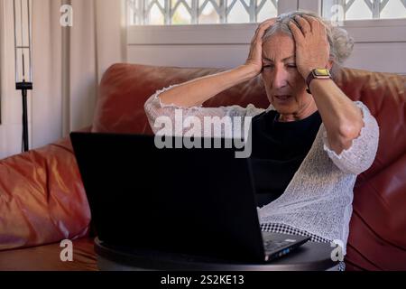 Frau im Ruhestand, die technische Probleme hat. Stockfoto