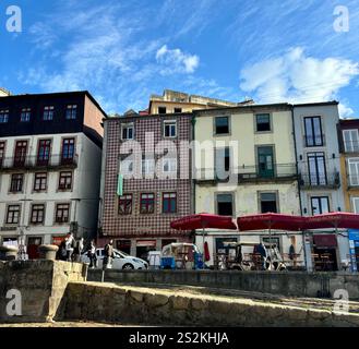 Wunderschöne historische Gebäude entlang der Uferpromenade von Porto, Portugal. Die farbenfrohen Fliesen und Farben zeigen Portos beeindruckende historische Architektur. Stockfoto